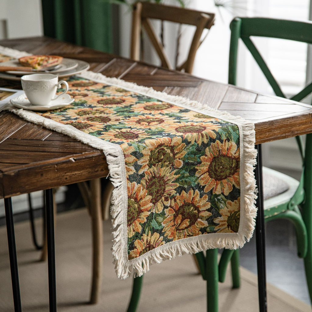 Decorative sunflower table runner on a wooden table with a cup and saucer.