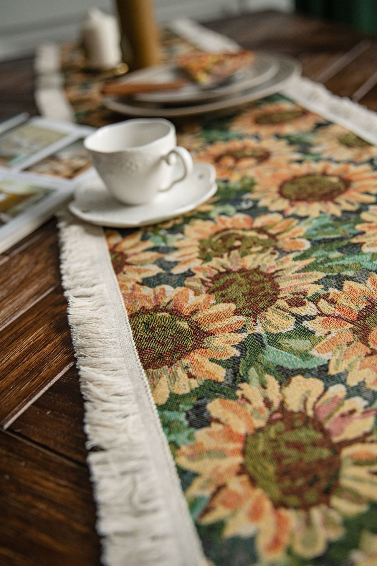 Decorative sunflower table runner on a wooden table with a cup and saucer.