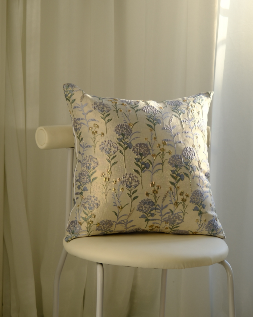 Floral-patterned pillow on a chair with a neutral background