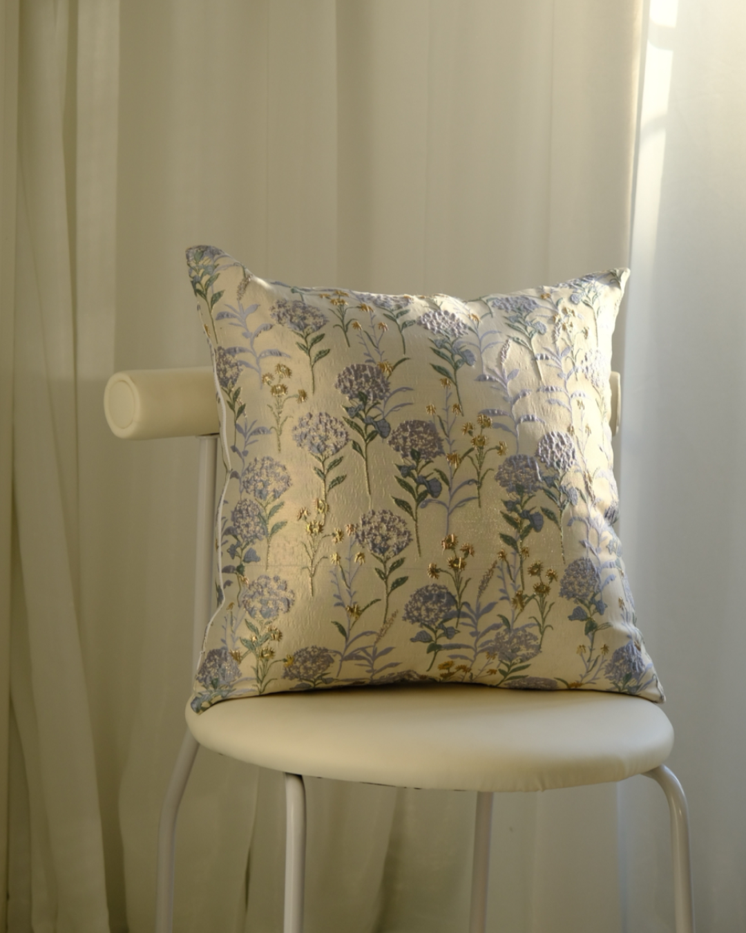 Floral-patterned pillow on a chair with a neutral background