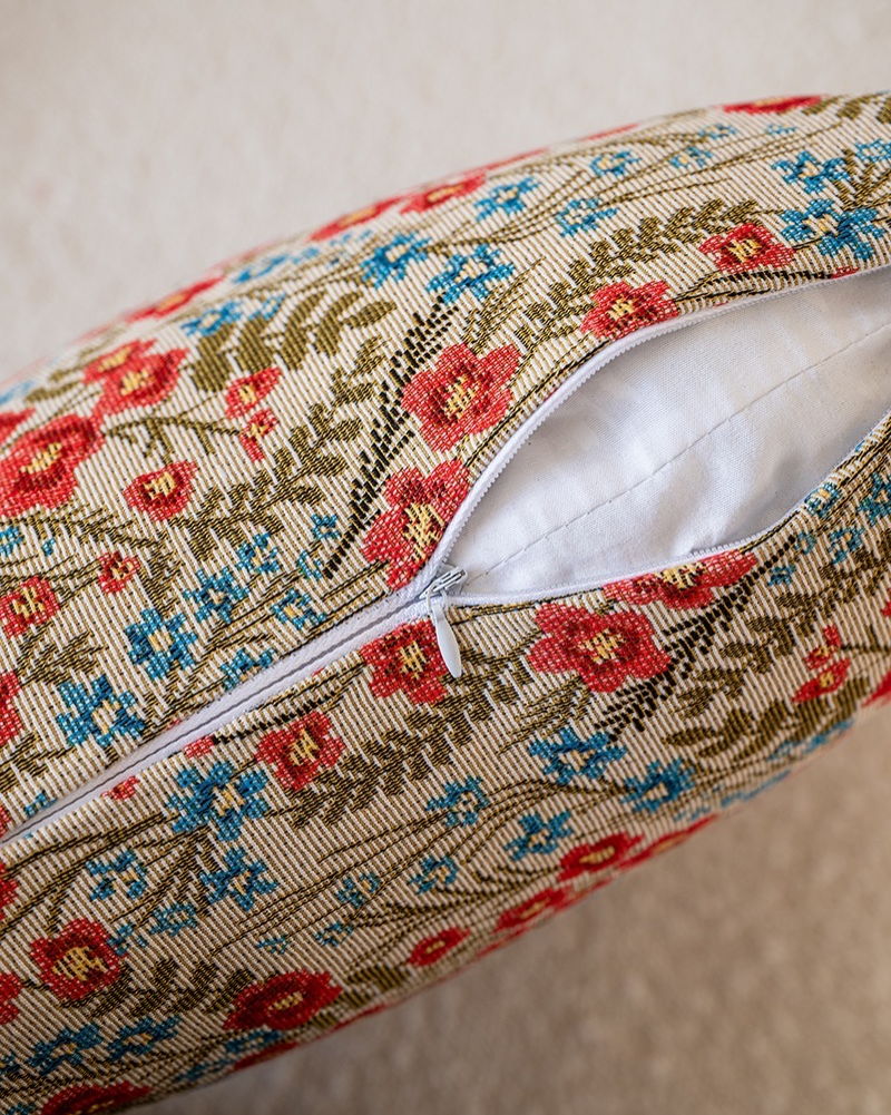 Close-up of red and green block-print floral on cushion