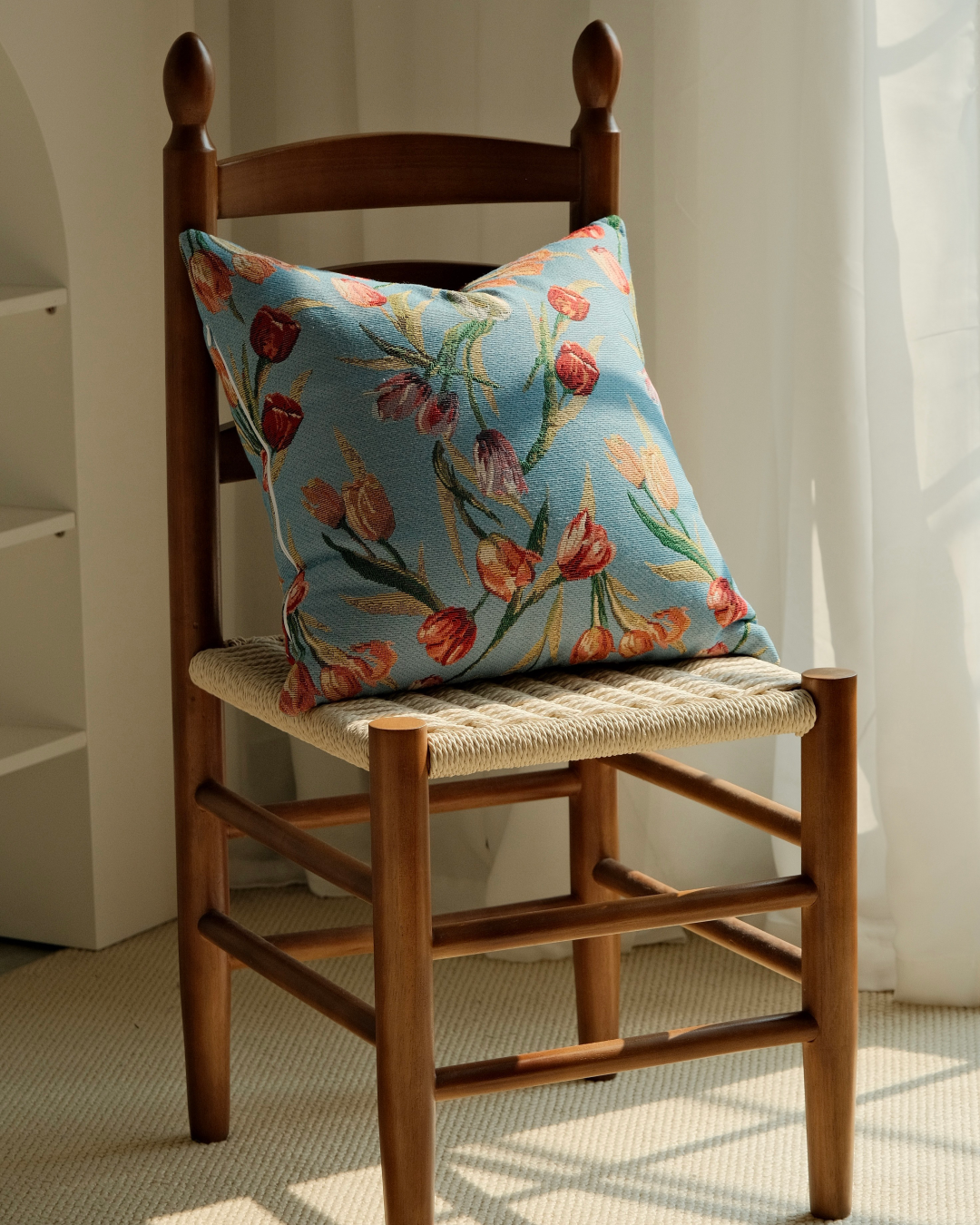 Blue tulip cushion on a wooden chair, cottage style