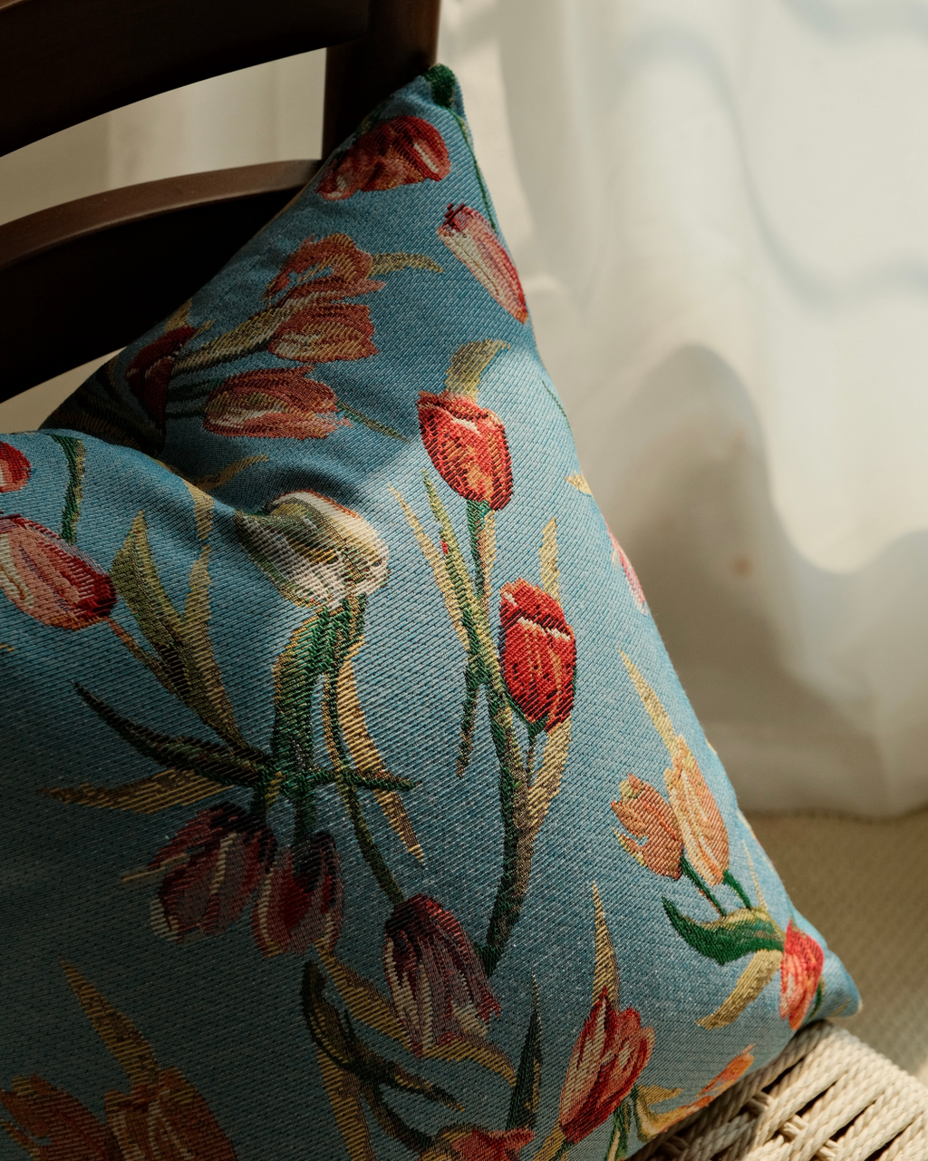 Close-up of coral tulip floral weave on blue cushion