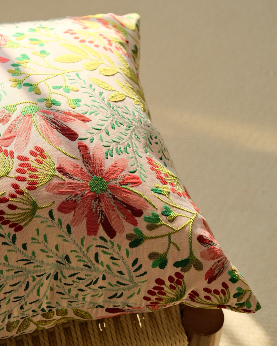 Close-up of pink daisy embroidered floral on cream cushion