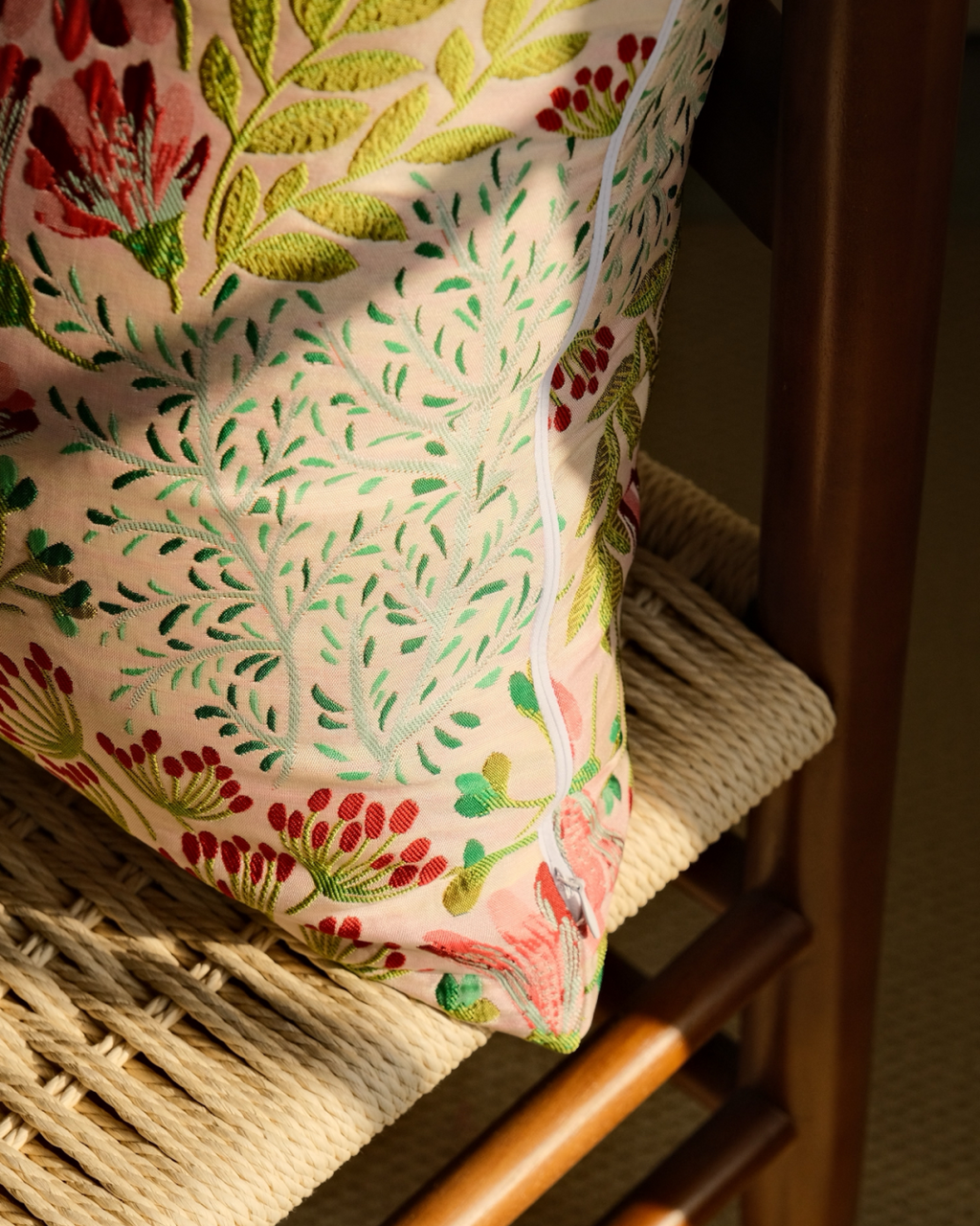 Textured embroidered wildflower pillow cover on a chair