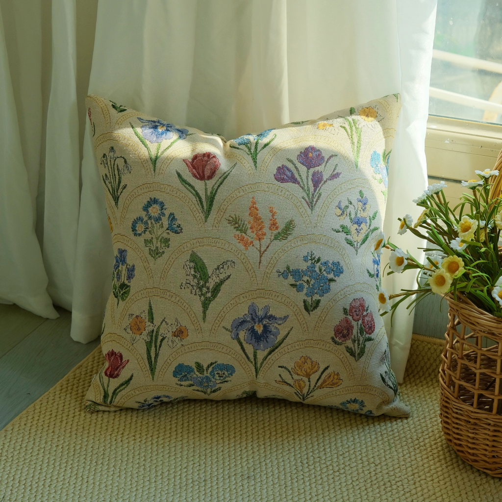 Watercolor floral cushion cover on a rug near a wooden cabinet