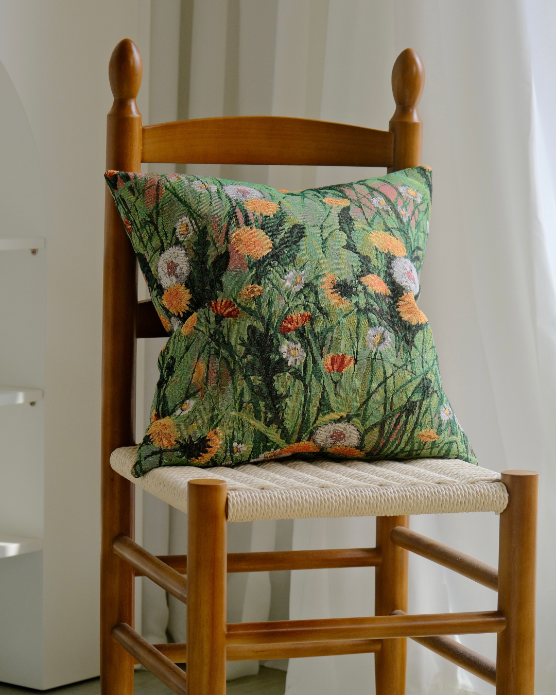 Wildflower meadow cushion cover on a rustic wooden chair