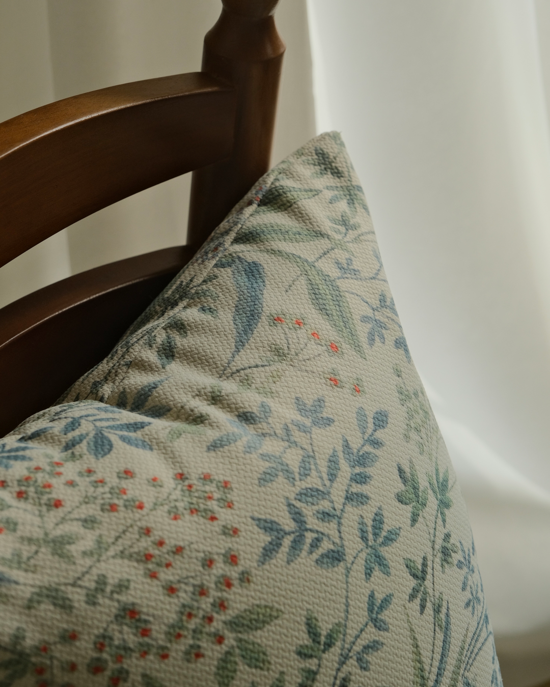 Close view of sage botanical sprig print on pillow cover corner