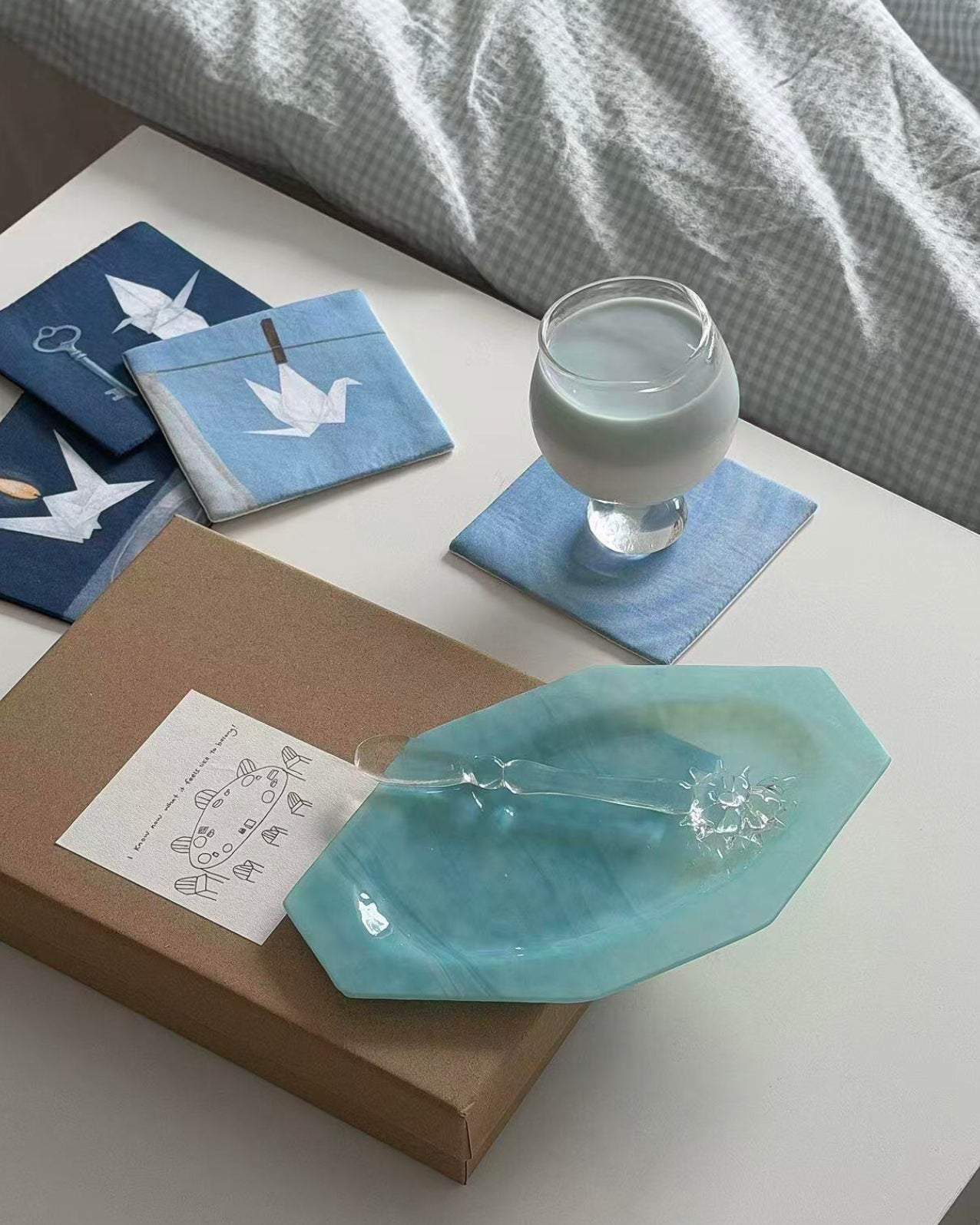 Blue and white coaster set styled with a linen napkin and teal dish