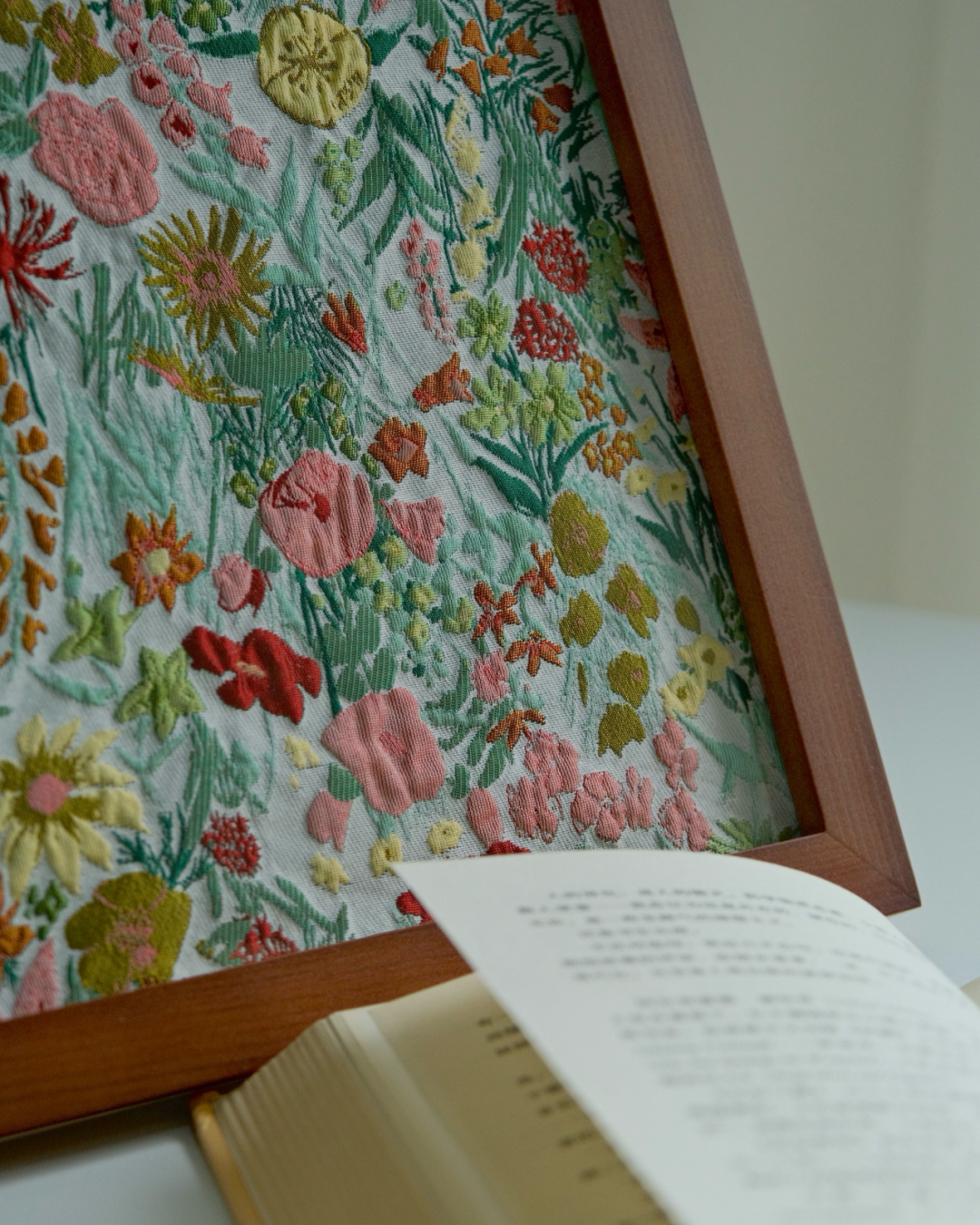 Cottage floral framed fabric art on a reading table