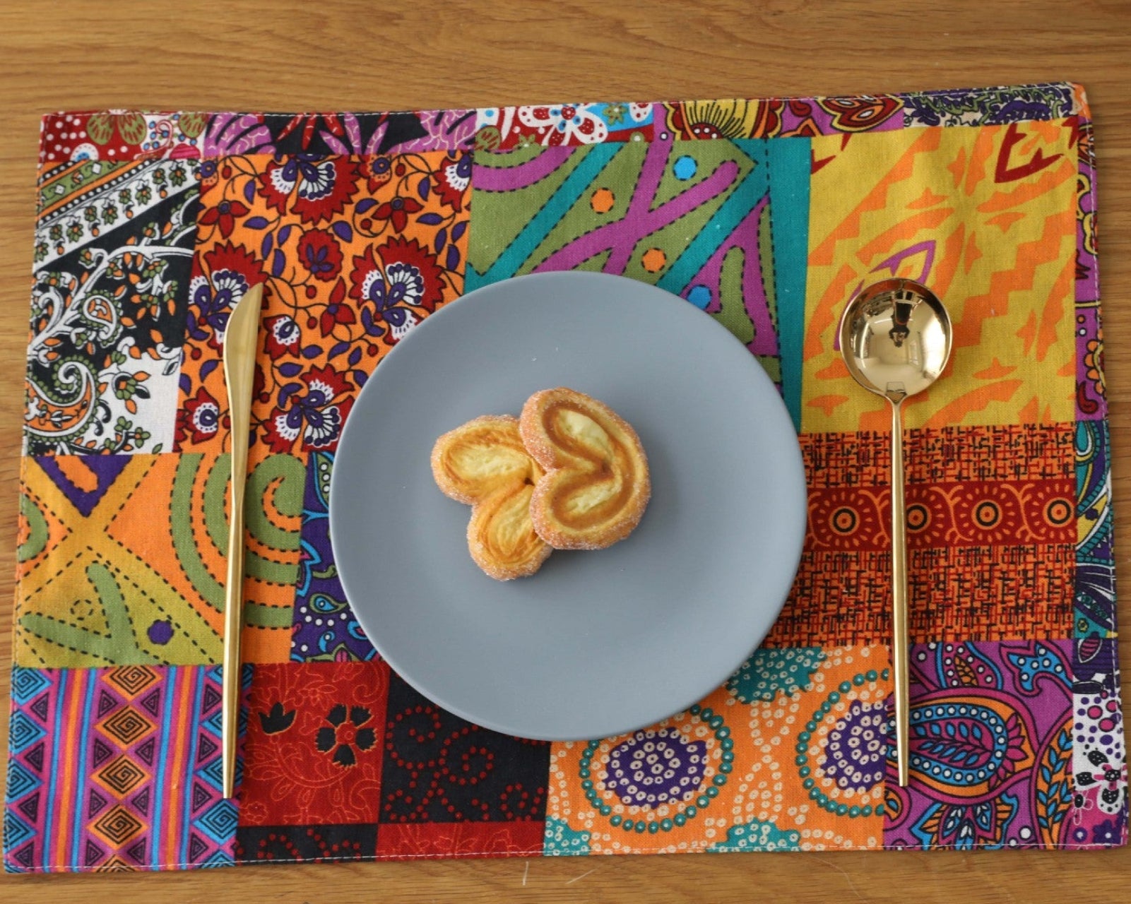 Bohemian patchwork placemat under a blue plate on wood table