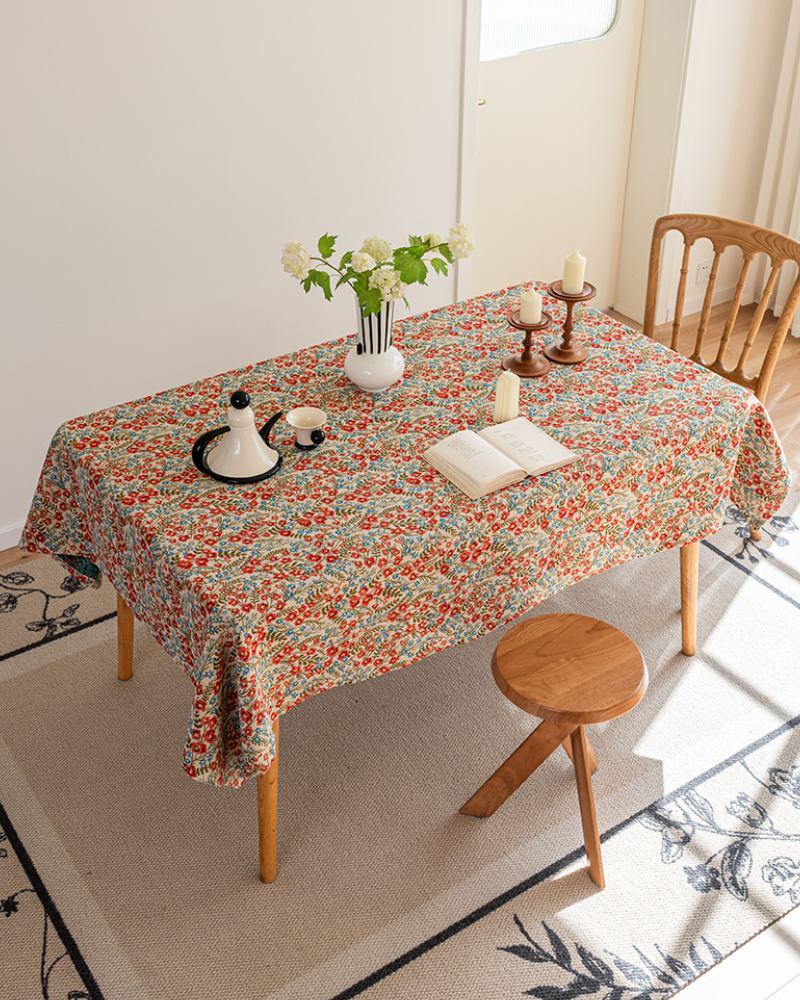 Wildflower Meadow tablecloth on a dining table with candlesticks and an open book