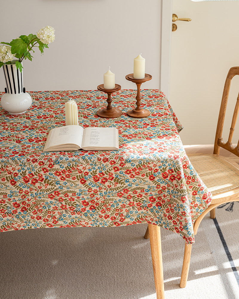 Wildflower floral tablecloth on a dining table with a rug and wooden chairs