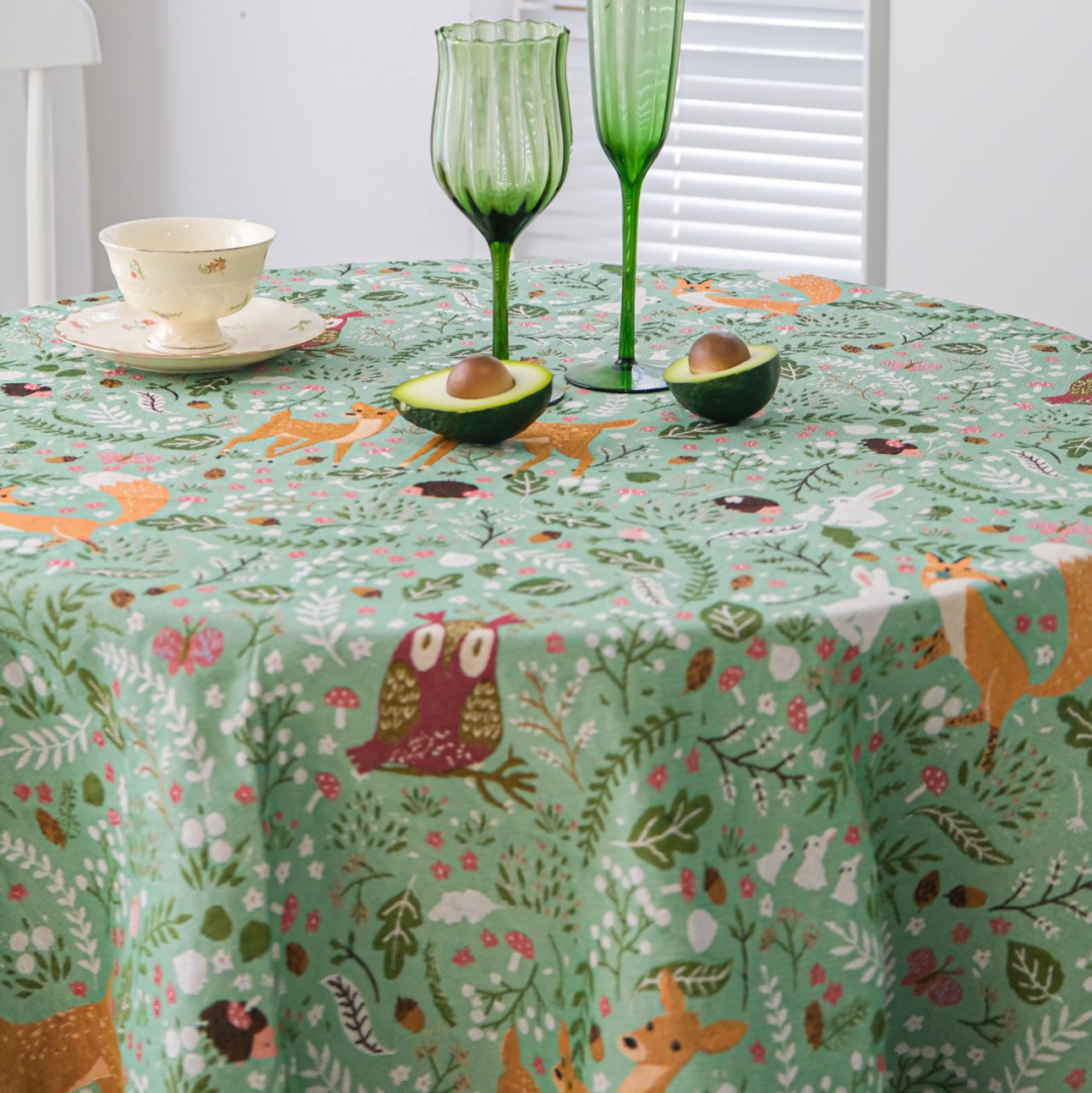 Woodland Fox and Deer tablecloth on a round table with teacup and glasses