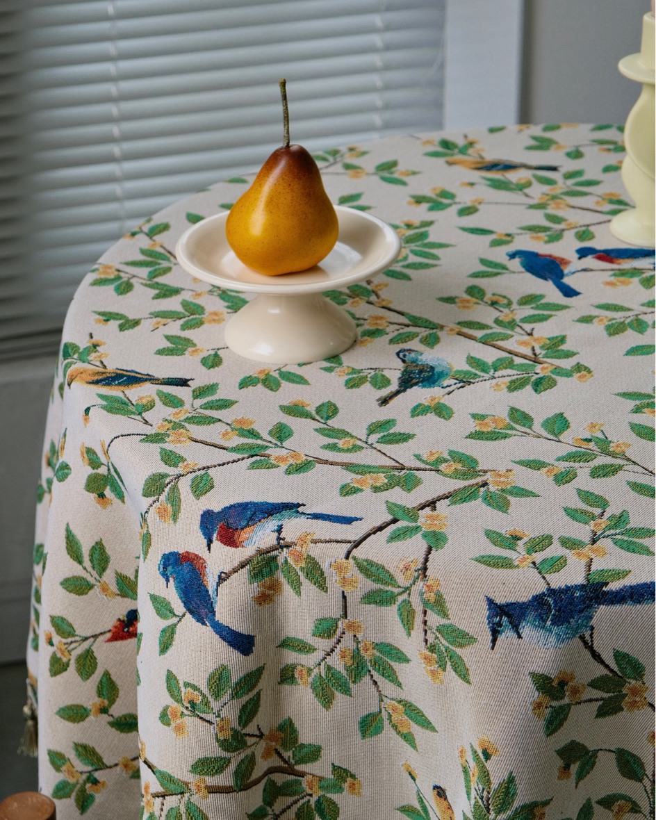 Bluebird Garden tasseled tablecloth with a pear on a pedestal dish