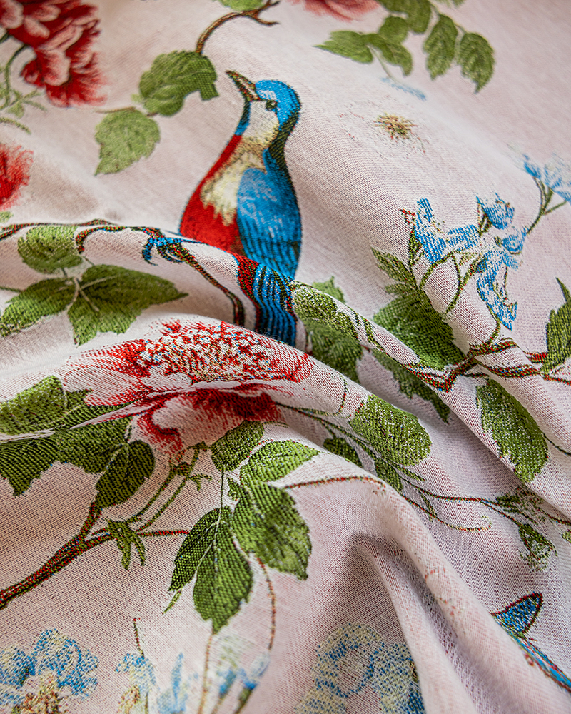 Close view of rose and bluebird print on tasseled tablecloth edge