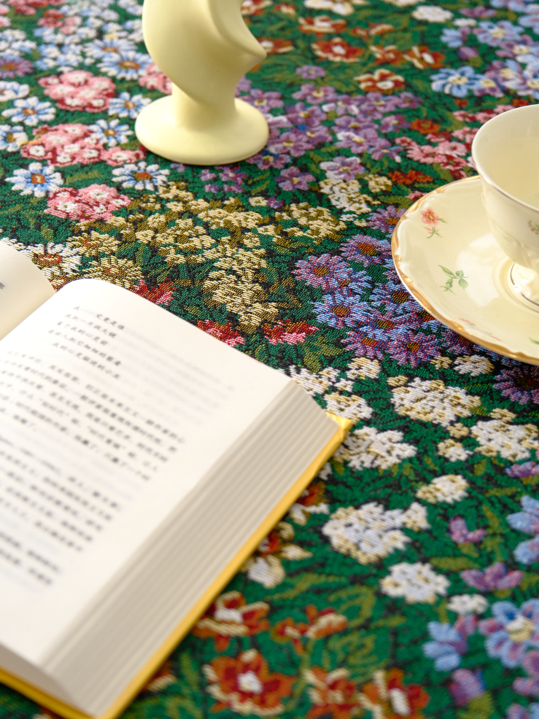 Close view of dense floral print on dark green tablecloth