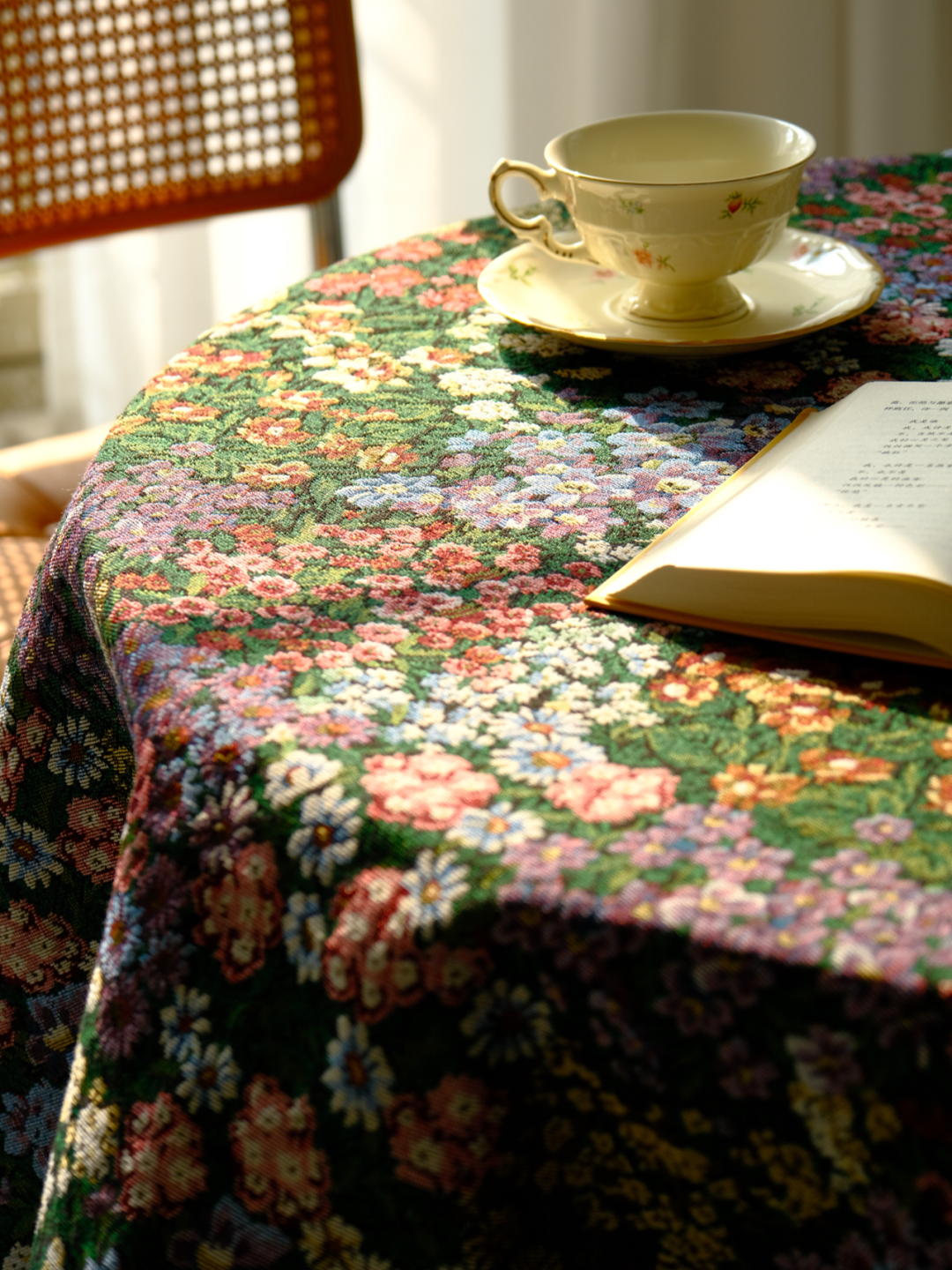 Dark floral tablecloth draped over a shelf corner with a teacup