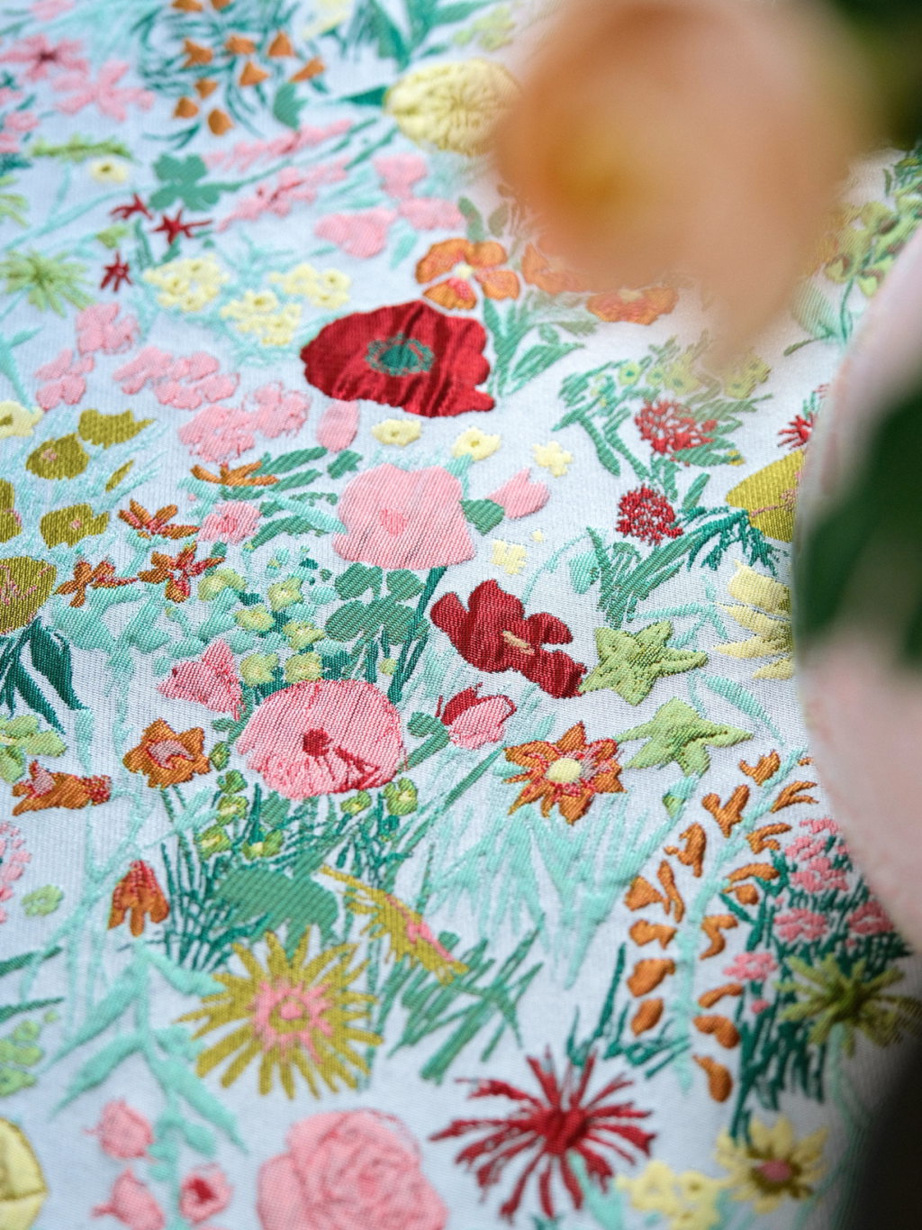 Close view of dense colorful floral pattern on mint green tablecloth