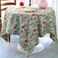 Bright floral garden tablecloth on a table with candles and roses