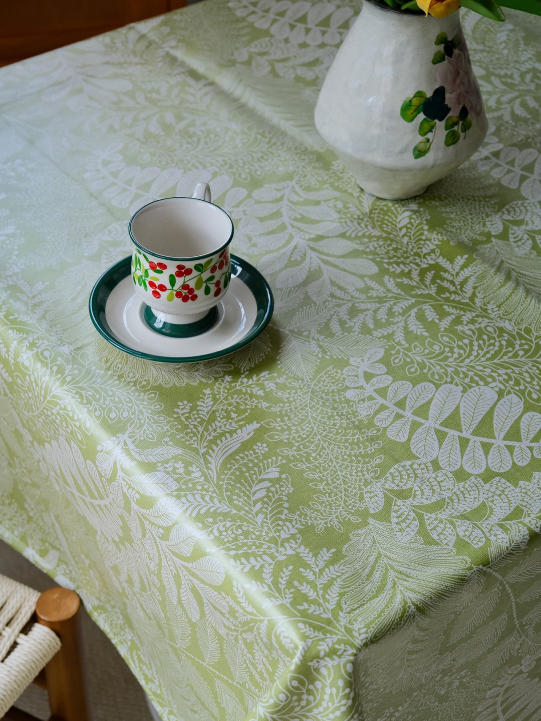 Close up view of sage green botanical fabric texture on dining table