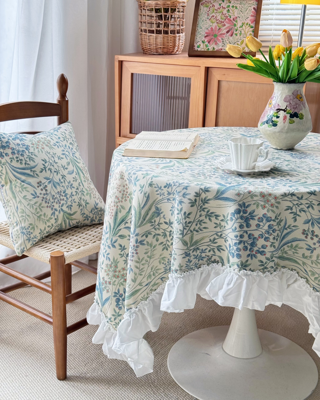 Blue floral ruffle tablecloth on a round dining table in a cottage dining room
