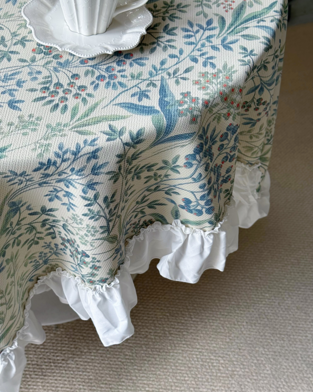 Close-up of ruffled edge on blue botanical tablecloth