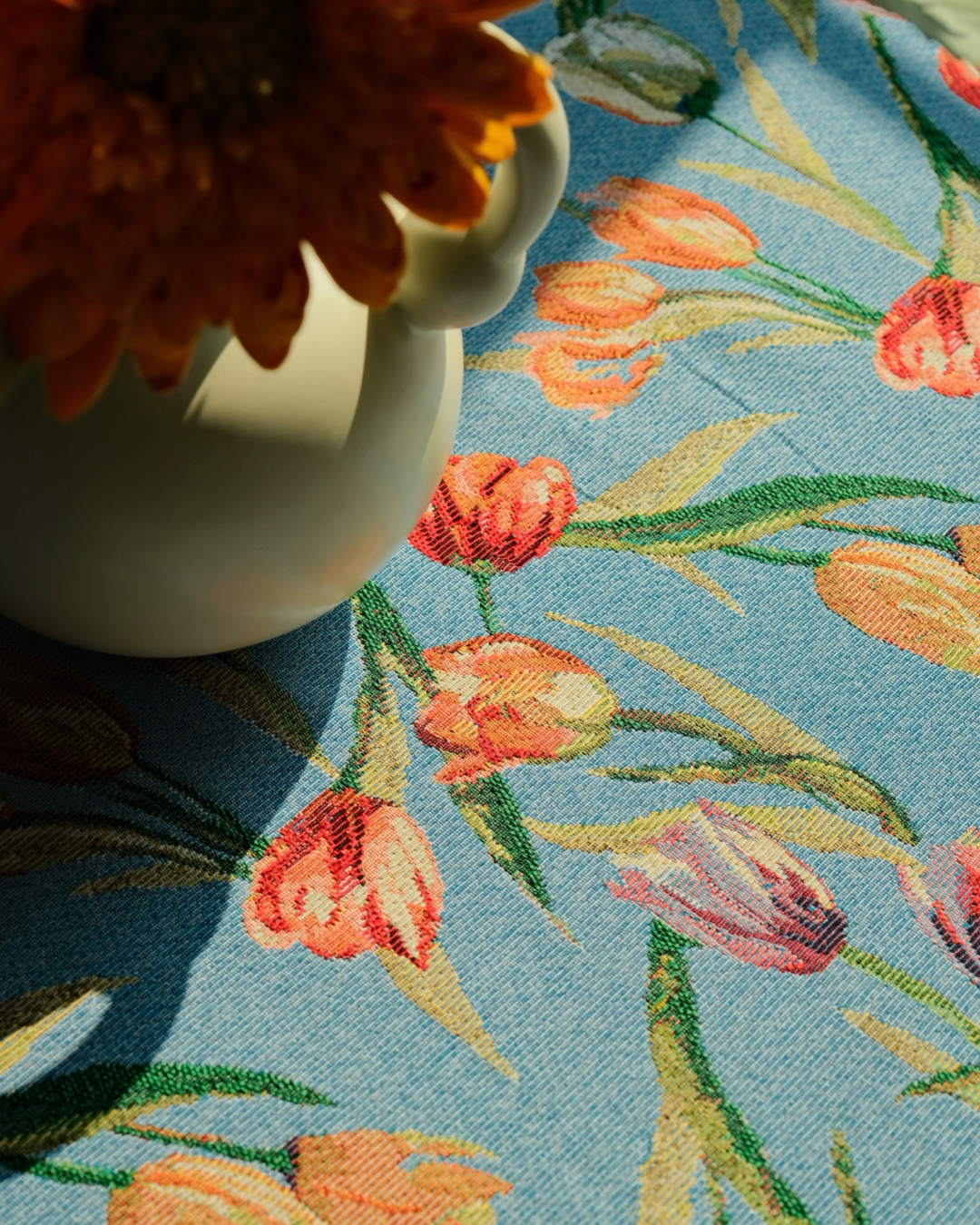 Detailed multicolor tulip floral pattern on blue tablecloth