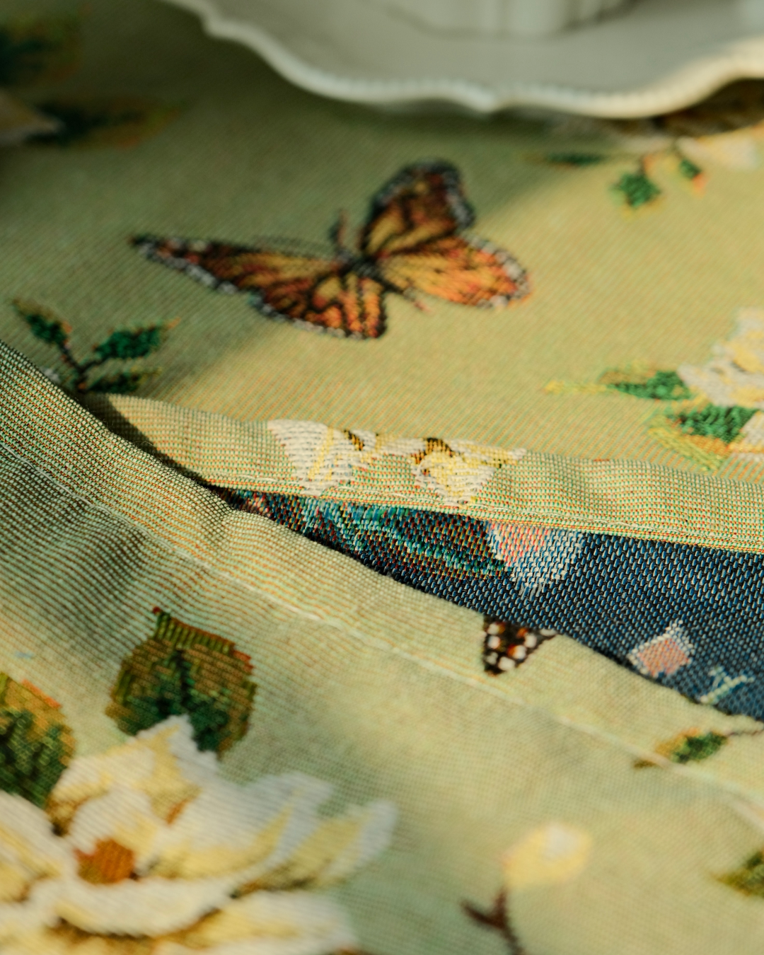 Close-up of butterfly and blossom woven tablecloth texture