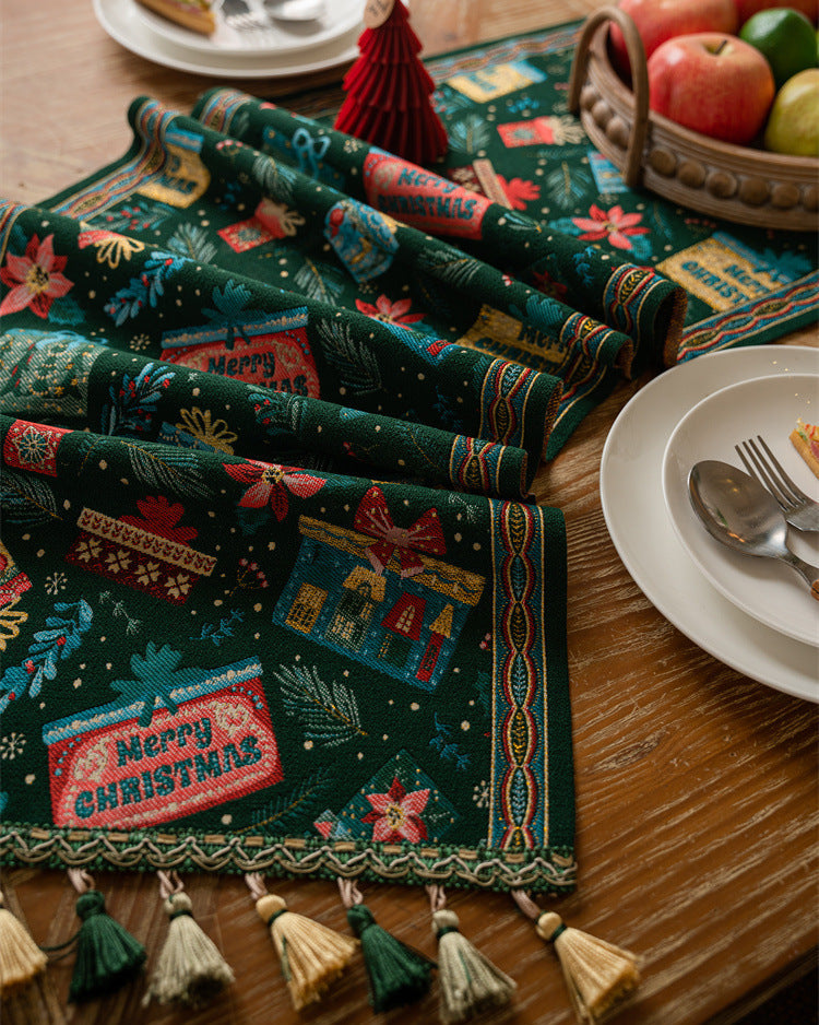 Decorative Christmas table runner with tassels on a wooden table.