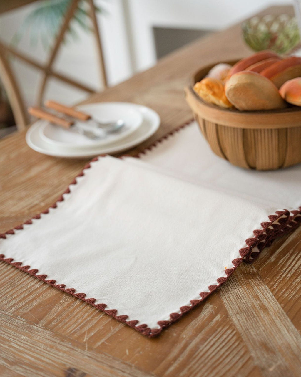 Close-up of terracotta scalloped crochet trim on a table runner