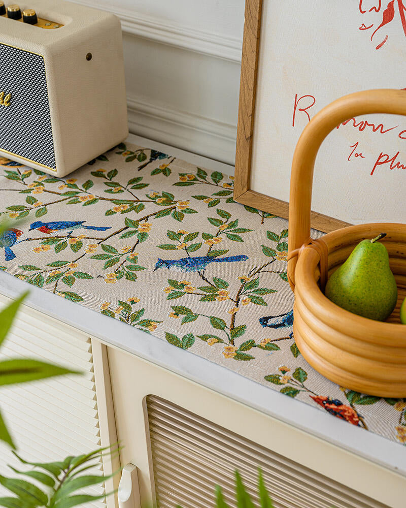 Bluebird tasseled table runner styled with a basket of pears