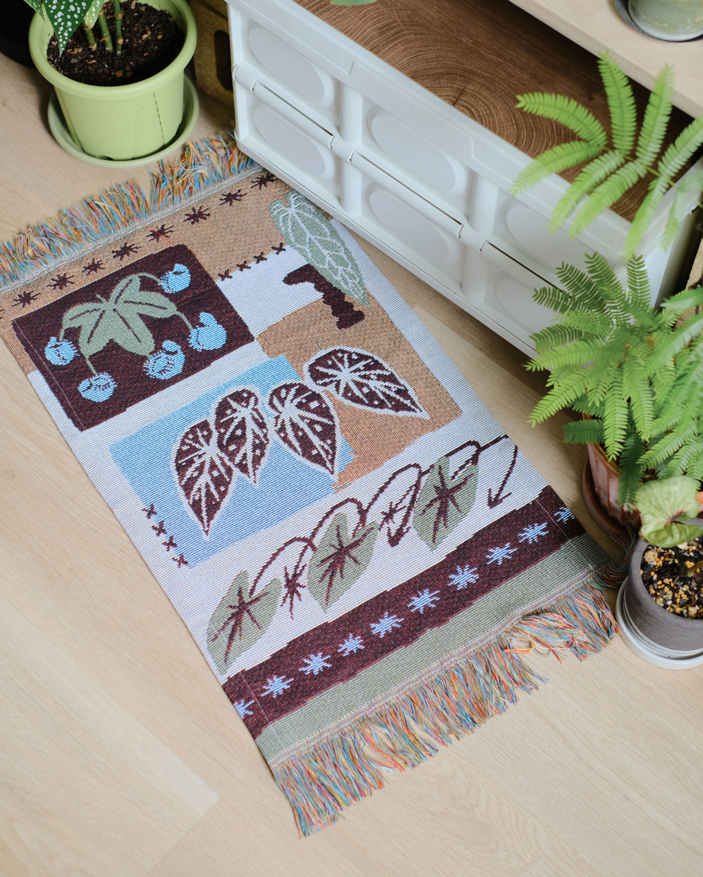 Tropical leaf woven runner styled on a wooden console with a plant